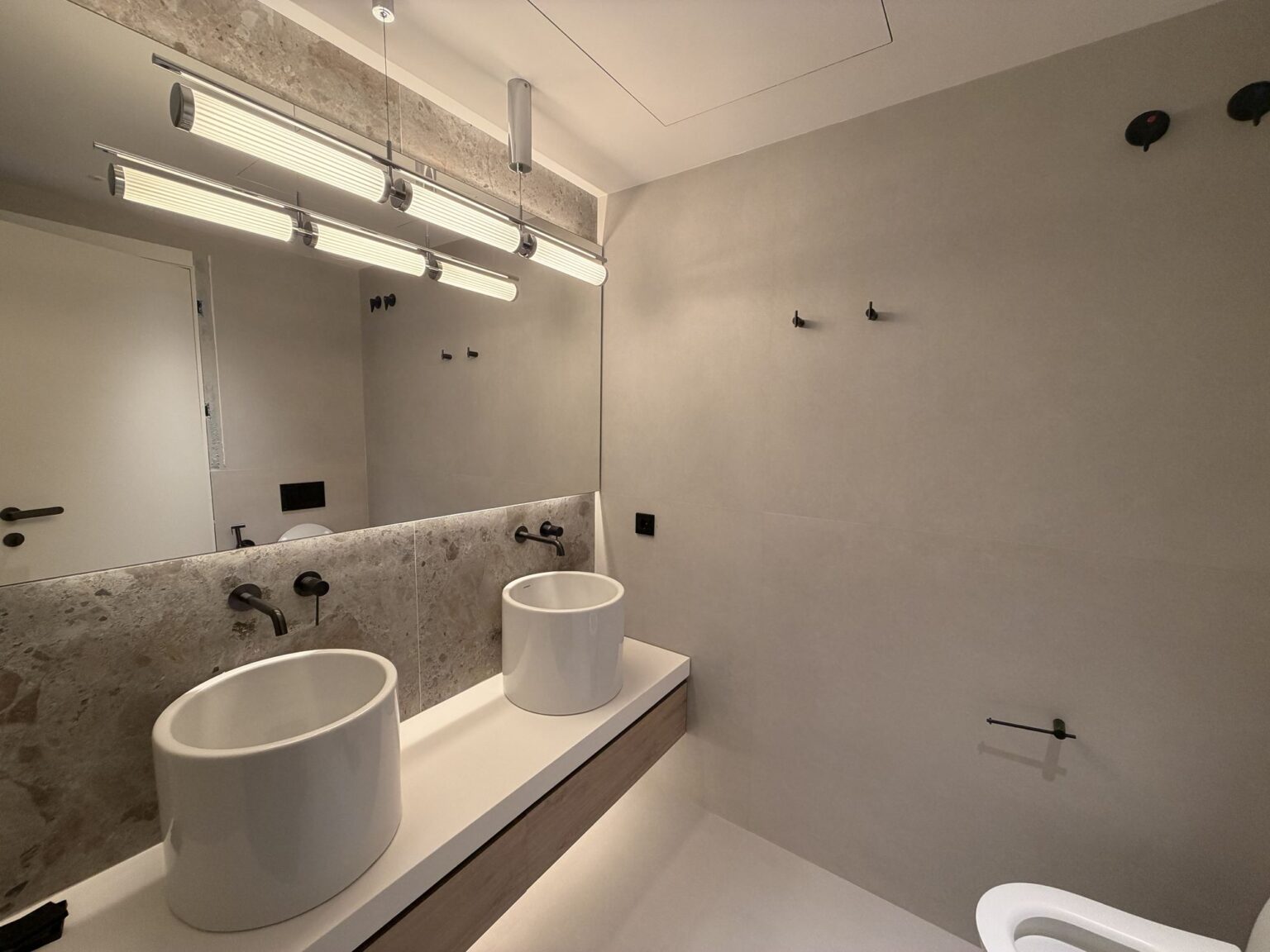 Baño con lavabos sobre encimera y piedra natural