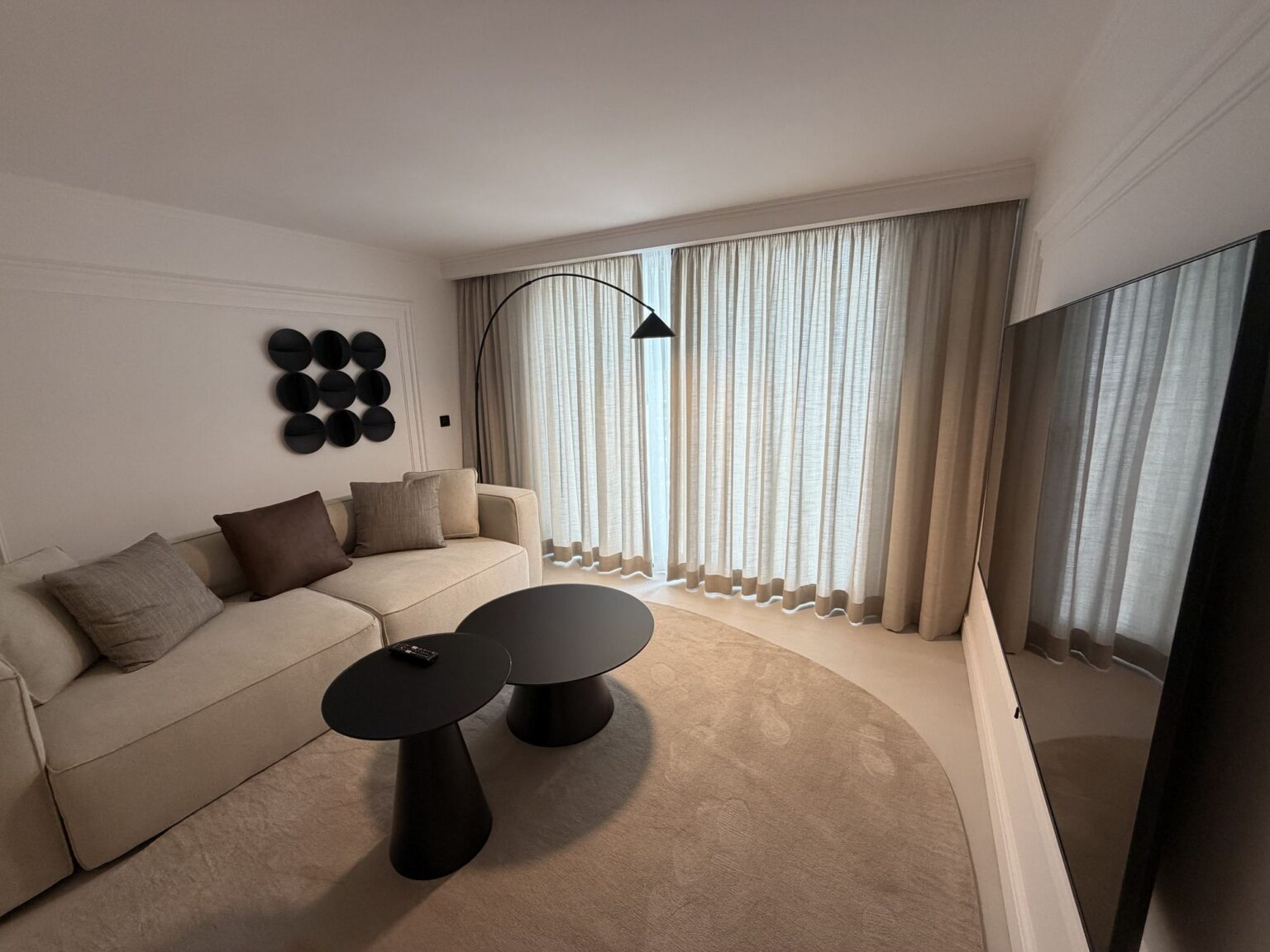 Sala de estar con sofá, mesas auxiliares y cortinas en la villa