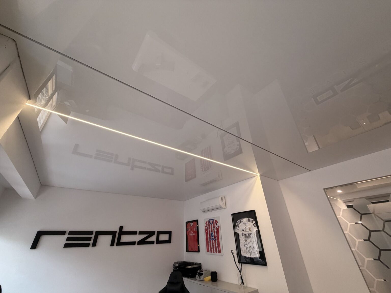 Techo tensado blanco con línea de luz LED perimetral en la oficina Rentzo