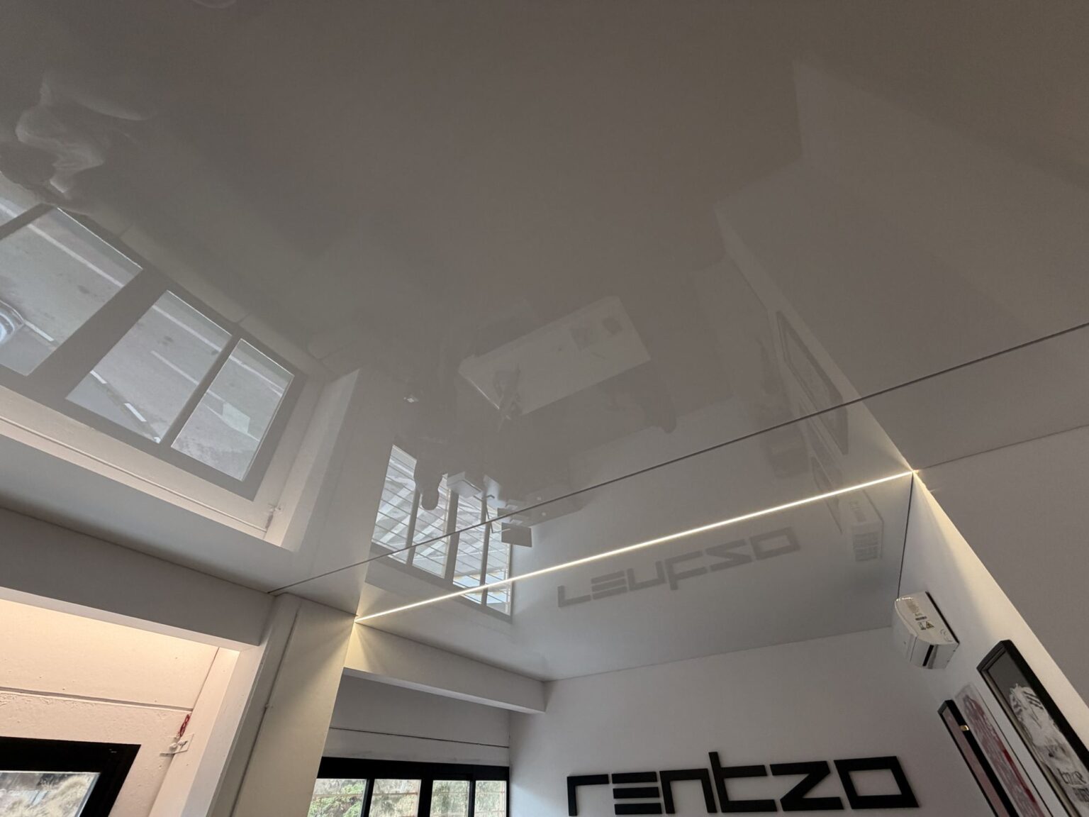 Detalle de la línea de luz integrada en el techo tensado de la oficina
