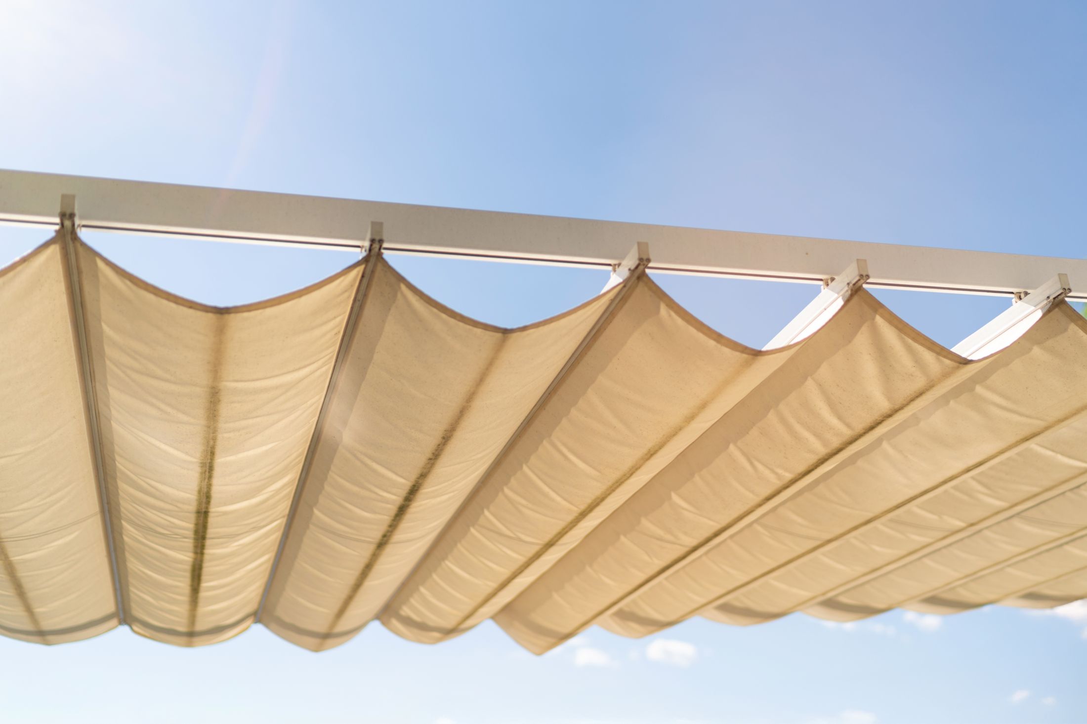 Toldo textil tensado bajo el cielo